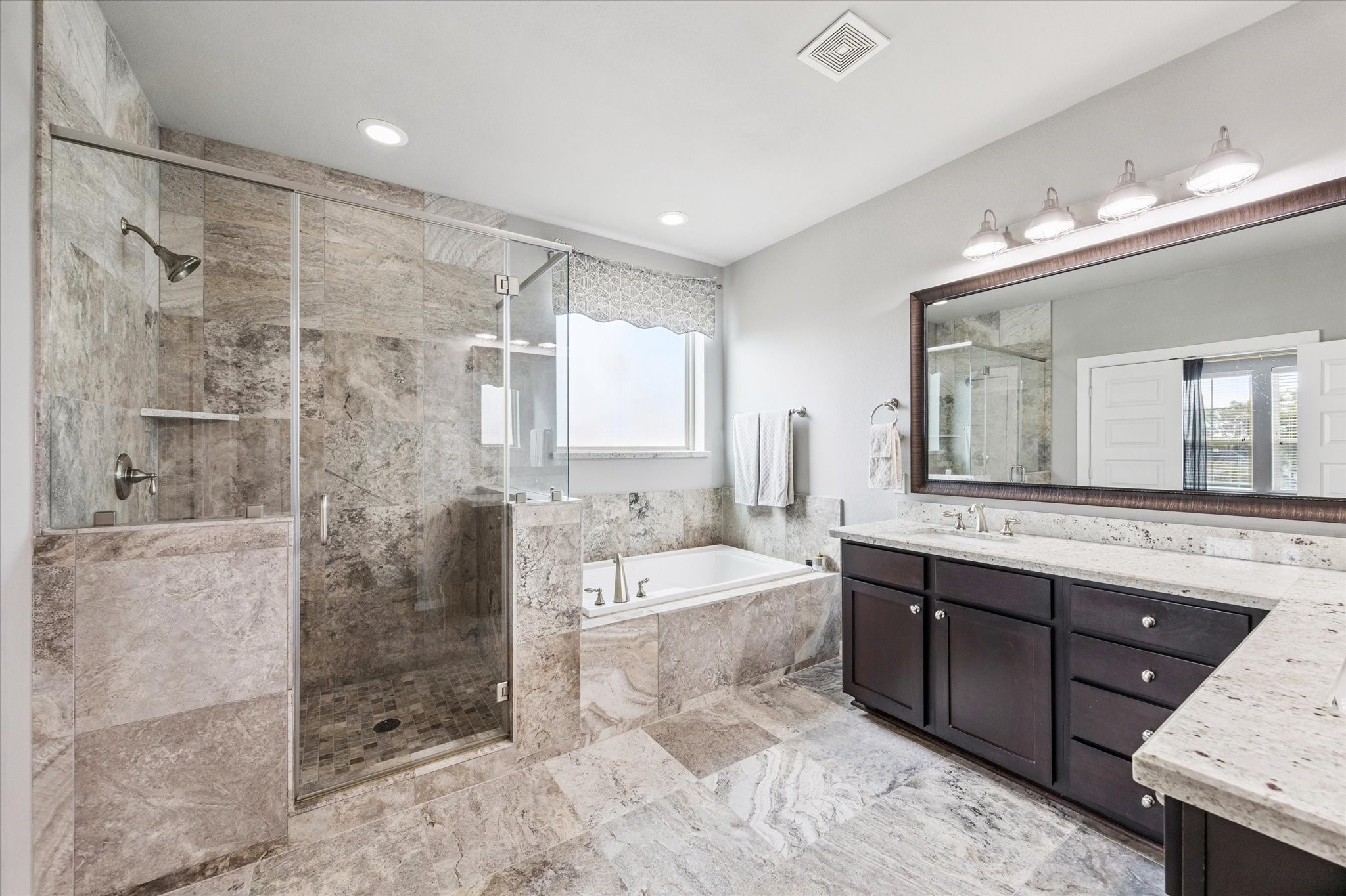 1702 Shearn Street Houston, TX 77007 - Photo 5 of 31 Brighten your day with ultimate relaxation as you unwind in the luxurious tub or the glass enclosed shower.