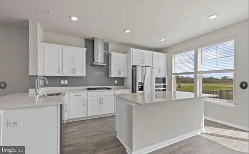 a kitchen with stainless steel appliances granite countertop a refrigerator and a stove top oven