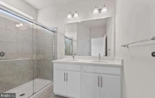 a bathroom with a double vanity sink mirror and shower