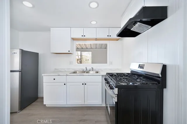 a kitchen with stainless steel appliances a stove a sink and a refrigerator