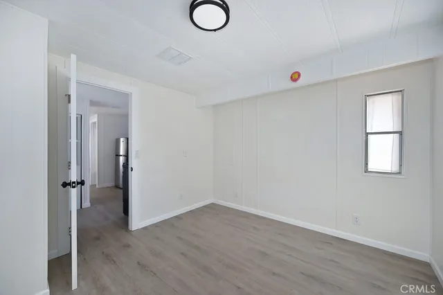 an empty room with wooden floor and window