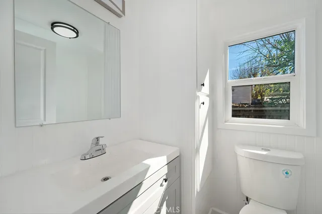 a bathroom with a sink a toilet and a mirror