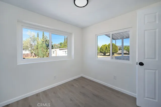 an empty room with windows and white door
