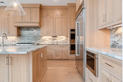 a kitchen with stainless steel appliances granite countertop a stove a sink and a refrigerator