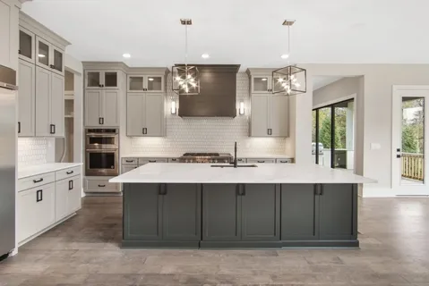 a large kitchen with a sink and dishwasher a stove with wooden floor