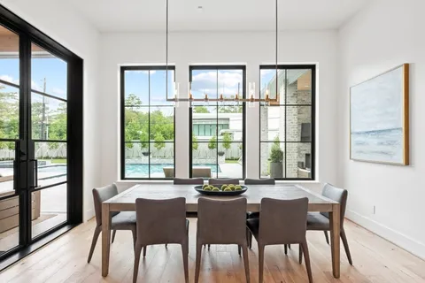 a view of a dining room with furniture large windows and wooden floor
