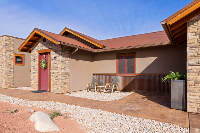 4173 Shadowfax Run, Unit 5 Moab, UT 84532 - Photo 8 of 41 Doorway to property featuring stone siding, stucco siding, a metal roof, and a patio area