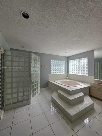 a spacious bathroom with a tub sink and mirror