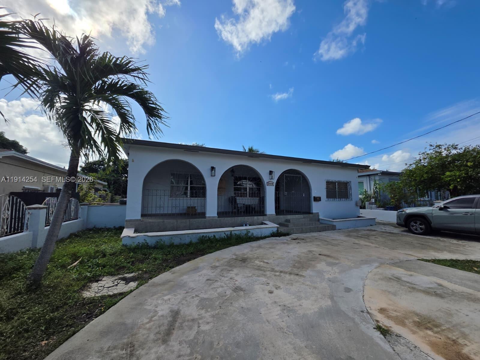 2970 Southwest 17th Street Miami, FL 33145 - Photo 3 of 27 a front view of a house with a yard and garage