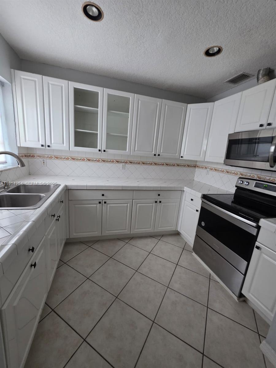 2970 Southwest 17th Street Miami, FL 33145 - Photo 9 of 25 a kitchen with a sink and cabinets