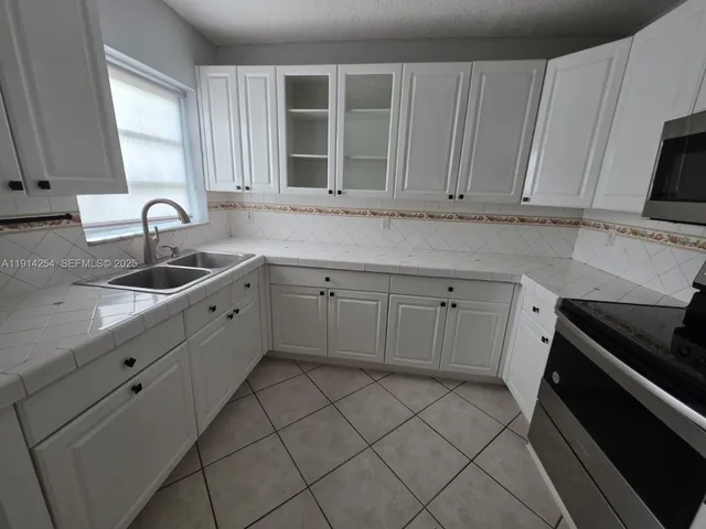 a kitchen with cabinets appliances and a sink