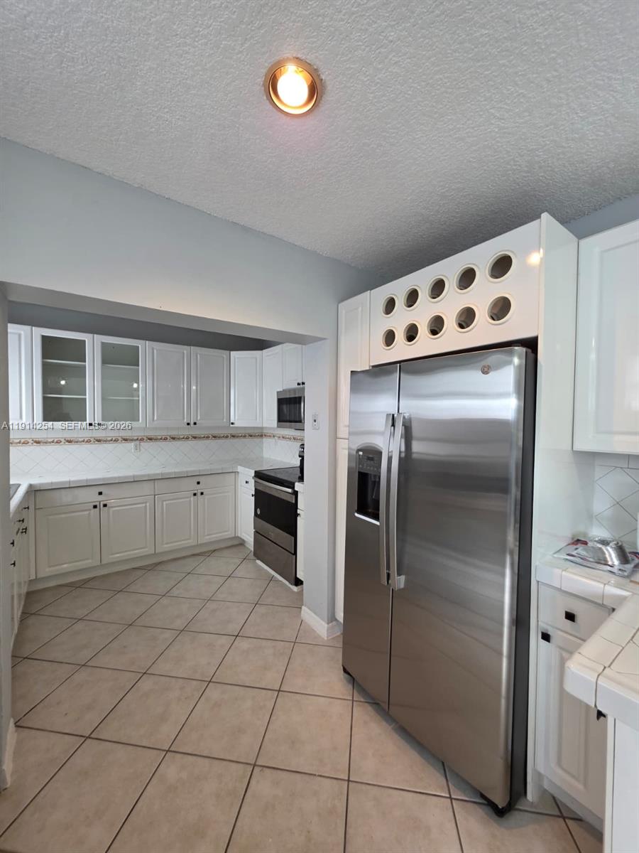 2970 Southwest 17th Street Miami, FL 33145 - Photo 10 of 27 a kitchen with white cabinets stainless steel appliances and a sink