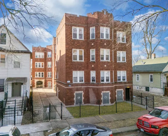 a front view of a brick building with a yard