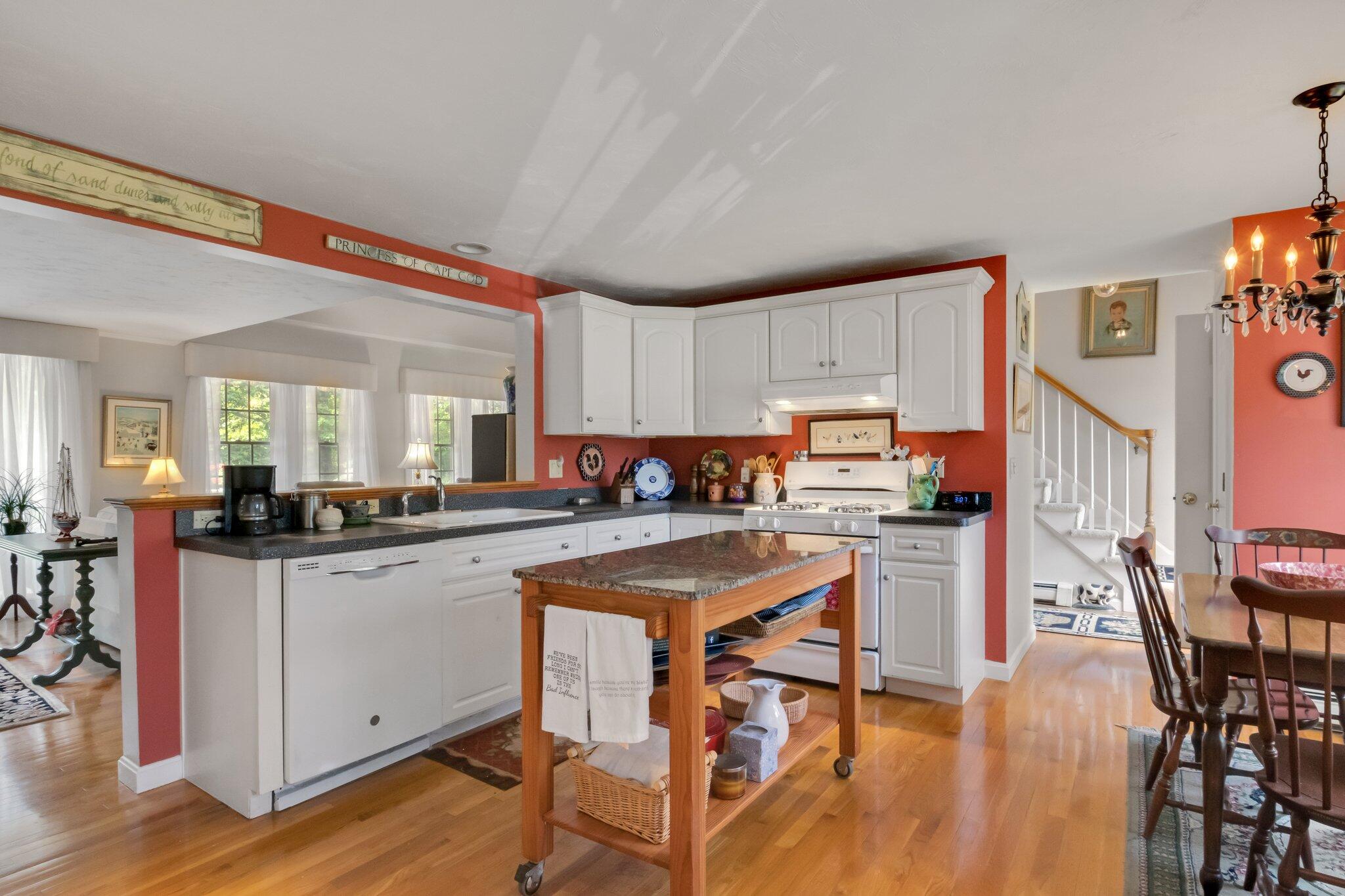107 Clipper Way Brewster, MA 02631 - Photo 12 of 60 a kitchen with stainless steel appliances granite countertop a stove top oven a sink dishwasher and white cabinets with wooden floor