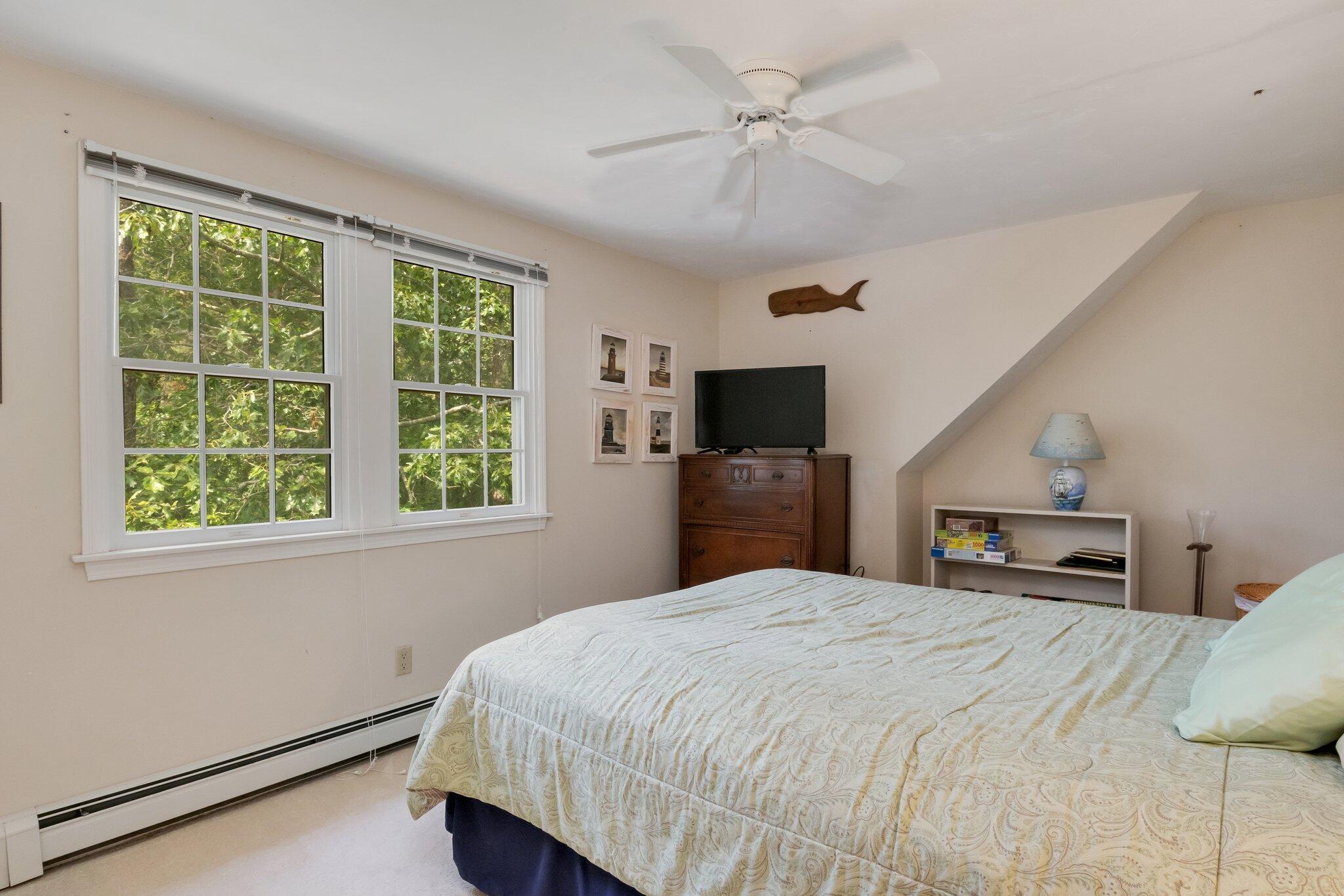107 Clipper Way Brewster, MA 02631 - Photo 22 of 60 a bedroom with a large bed and a tv