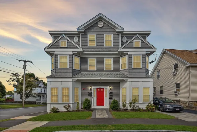 a front view of a house with a yard and trees