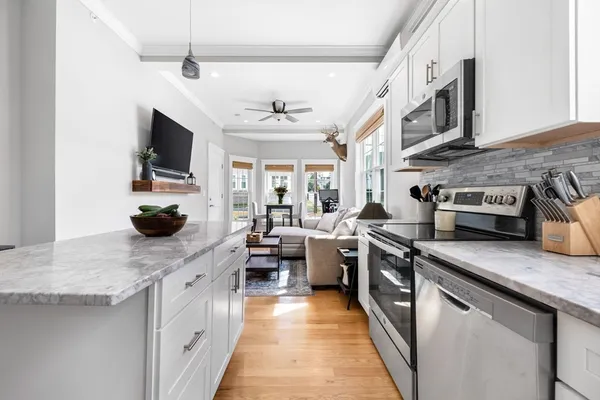 a kitchen with stainless steel appliances granite countertop a sink a stove and a wooden floors