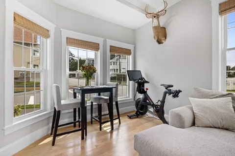 a view of a livingroom and dining room with wooden floor windows