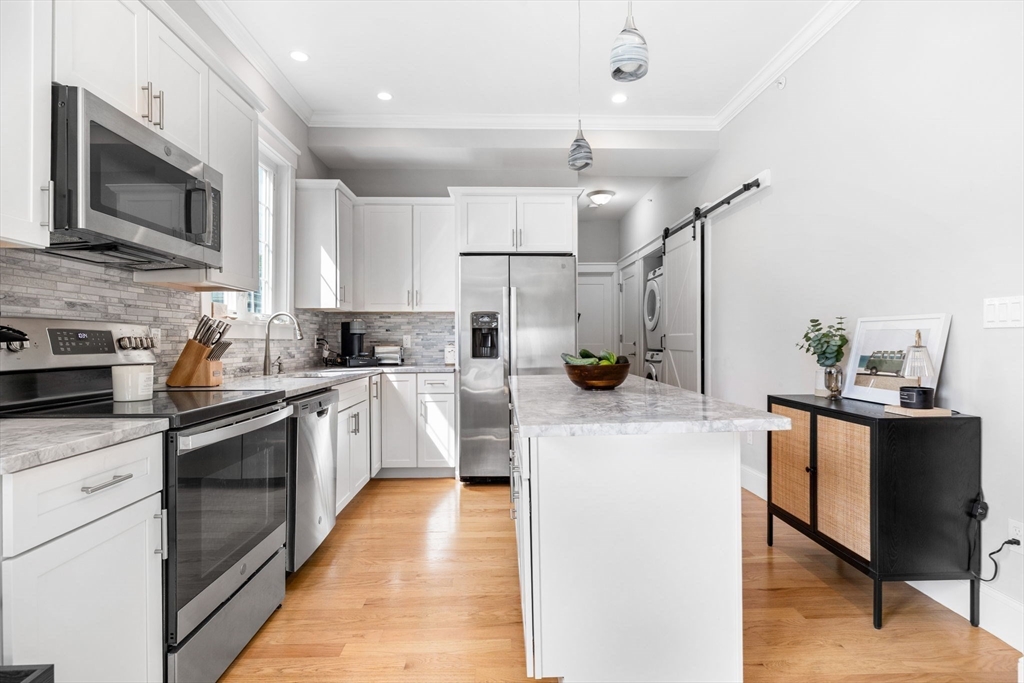 127 Marblehead Street, Unit A North Andover, MA 01845 - Photo 7 of 30 a kitchen with stainless steel appliances kitchen island granite countertop a sink a stove top oven a counter space and cabinets