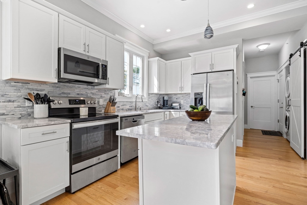 127 Marblehead Street, Unit A North Andover, MA 01845 - Photo 8 of 30 a kitchen with stainless steel appliances granite countertop a sink a stove a refrigerator a center island with wooden floor and cabinets
