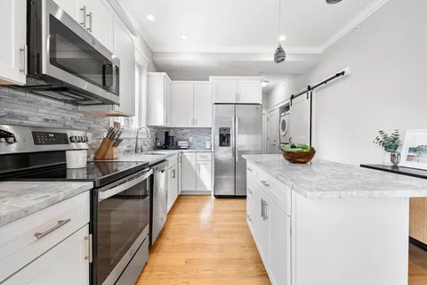 a kitchen with stainless steel appliances granite countertop a sink and a microwave