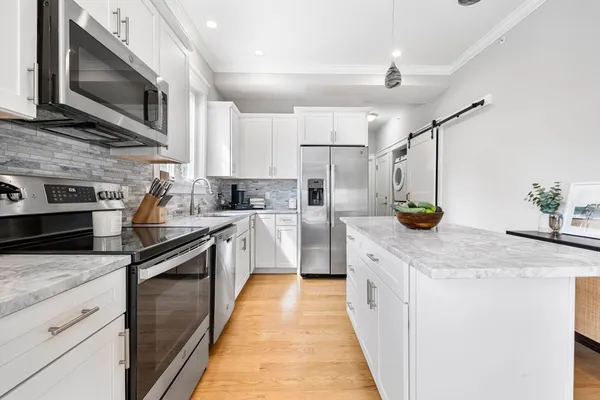 a kitchen with stainless steel appliances granite countertop a sink and a microwave