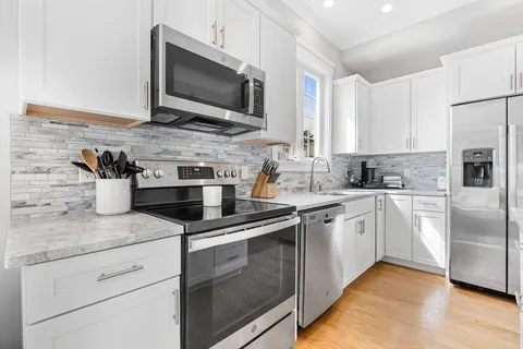 a kitchen with stainless steel appliances granite countertop a sink and a microwave