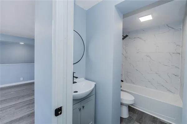 a bathroom with a sink a toilet and shower