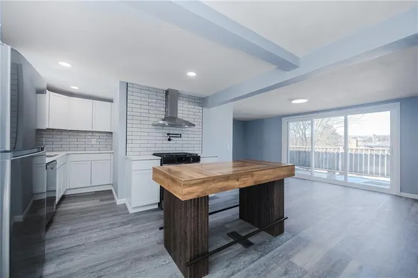 a kitchen with kitchen island a sink stove and refrigerator