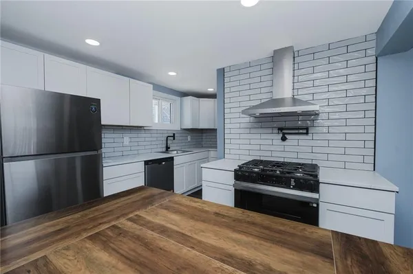 a kitchen with a refrigerator and a stove top oven