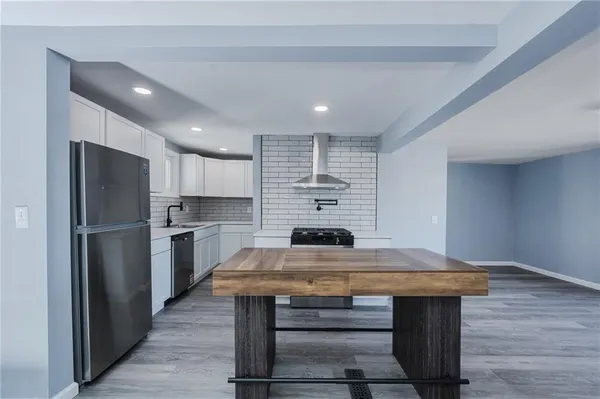 a kitchen with kitchen island a sink cabinets and stainless steel appliances