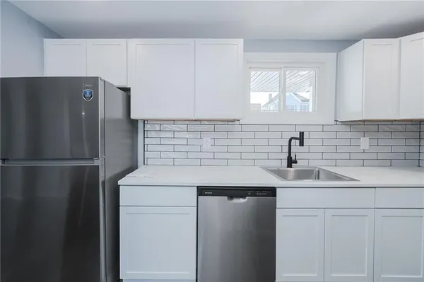 a kitchen with stainless steel appliances a refrigerator sink and cabinets