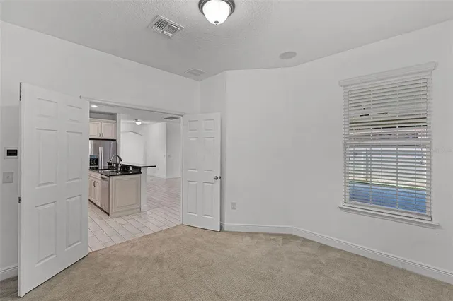 a kitchen with a refrigerator and white cabinets