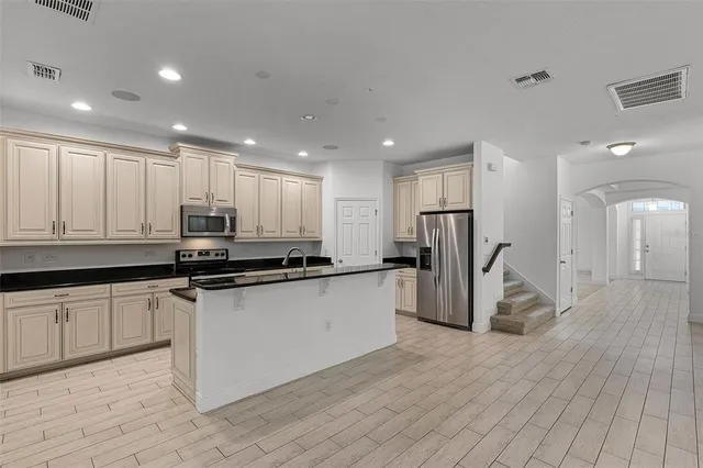 a kitchen with granite countertop a refrigerator and a sink