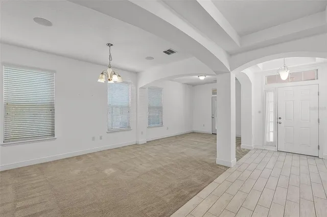 a view of an empty room with a chandelier