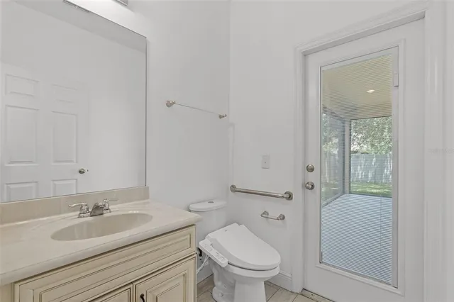 a bathroom with a granite countertop sink toilet and mirror