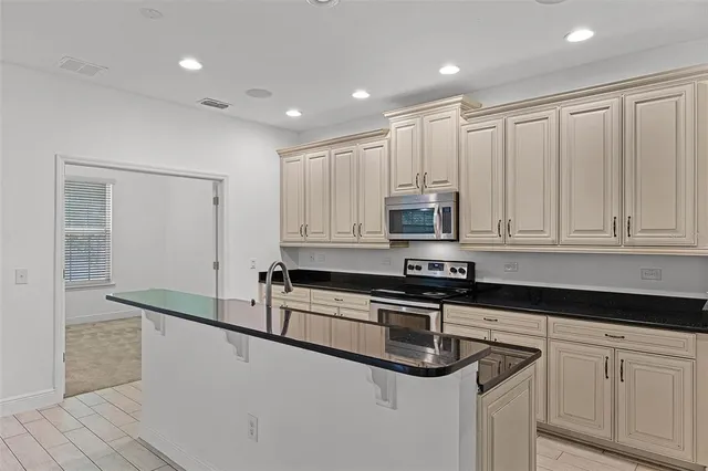 a kitchen with stainless steel appliances granite countertop white cabinets and a granite counter tops