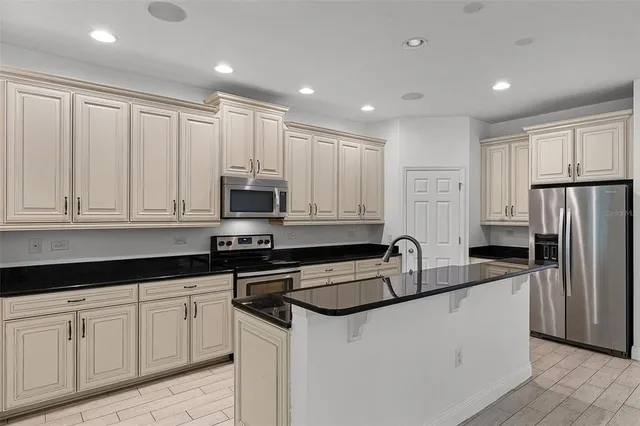 a kitchen with granite countertop white cabinets and stainless steel appliances