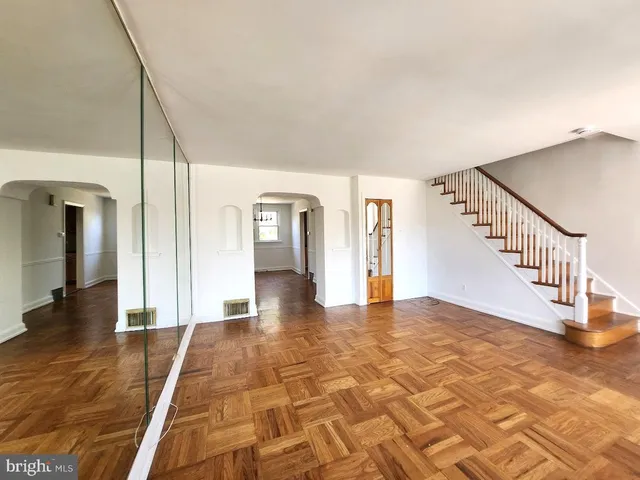a view of empty room with wooden floor