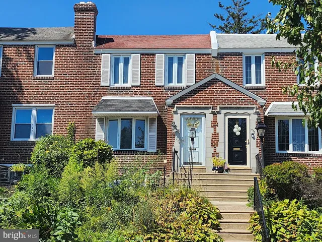 front view of a brick house with a small yard