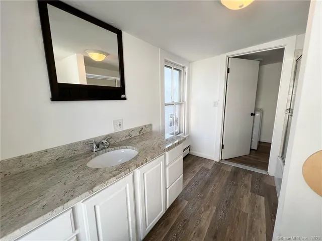 a bathroom with a granite countertop double vanity sink and a mirror
