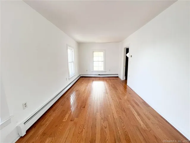 a view of a room with wooden floor and window