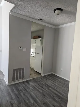 a kitchen with a refrigerator and white cabinets