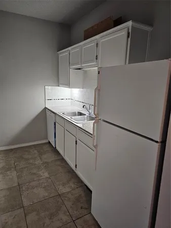 a kitchen with white cabinets and white appliances