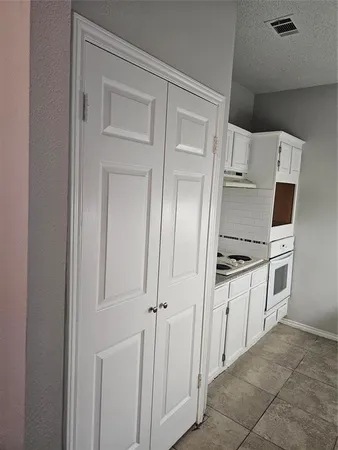 a kitchen with white cabinets and white appliances
