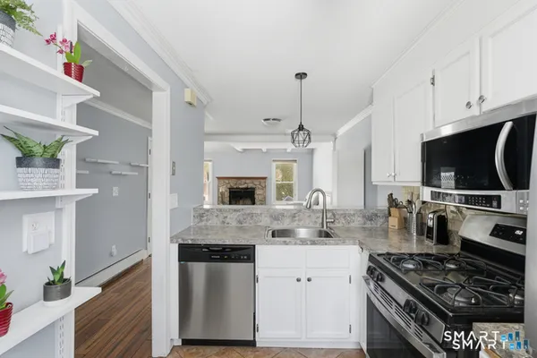 a kitchen with stainless steel appliances kitchen island granite countertop a stove and a sink