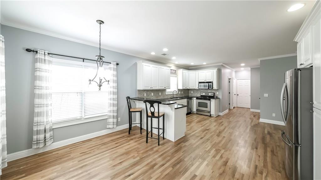 896 Winn Road Douglasville, GA 30134 - Photo 7 of 64 a open kitchen with stainless steel appliances granite countertop a refrigerator a stove and a wooden floors