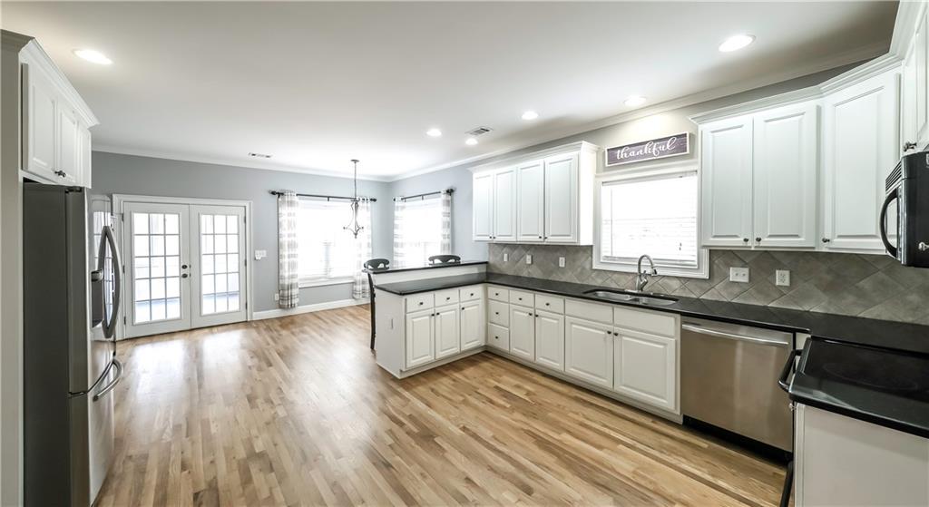 896 Winn Road Douglasville, GA 30134 - Photo 9 of 64 a large kitchen with granite countertop a large window a sink and stainless steel appliances