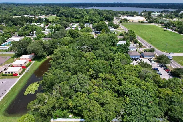 an aerial view of residential houses with outdoor space and trees