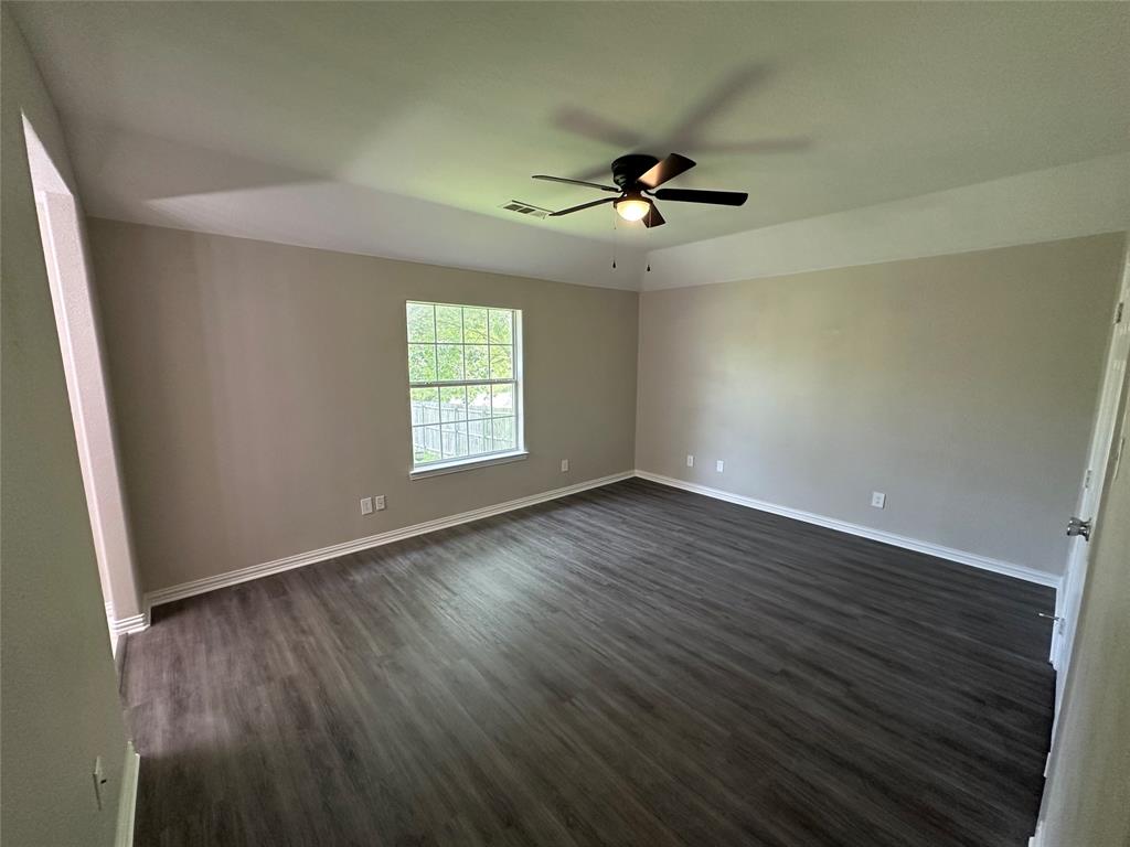 1160 South Beltline Road Dallas, TX 75253 - Photo 14 of 18 an empty room with wooden floor fan and windows